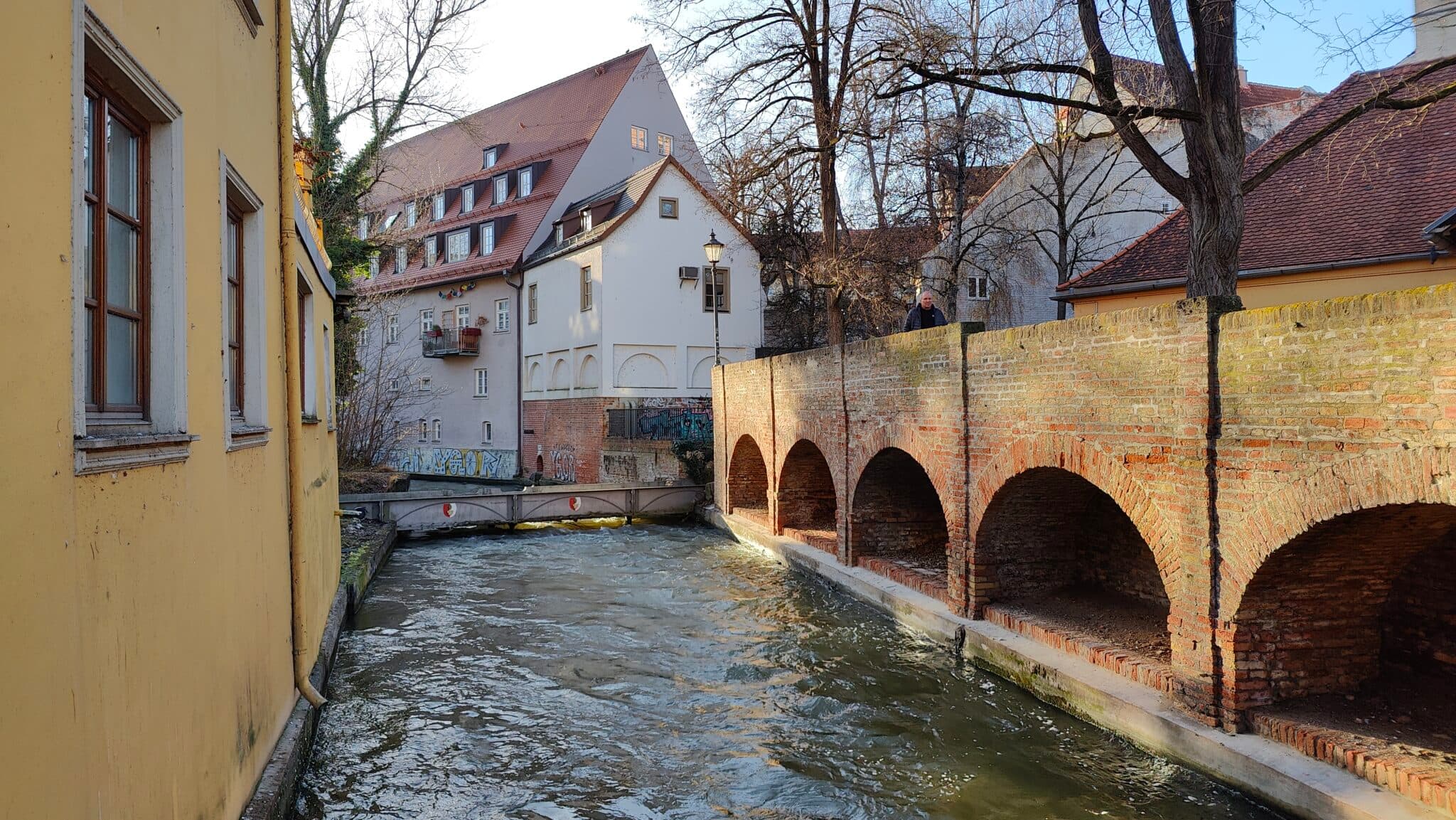 Blick über den Lechkanal auf das Gebäude von Kuhl & Engel in der Augsburger Altstadt